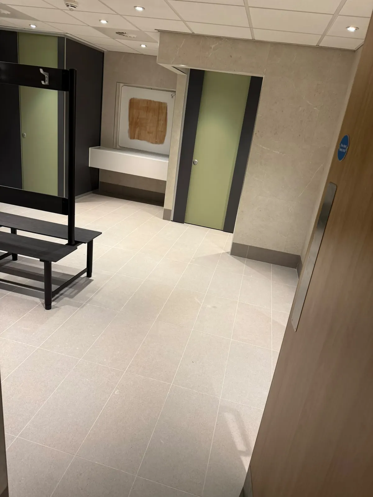 Lockers, bench seating and a vanity shelf, with Unika Light wall tiles and a tiled skirting in EXT Core Grey