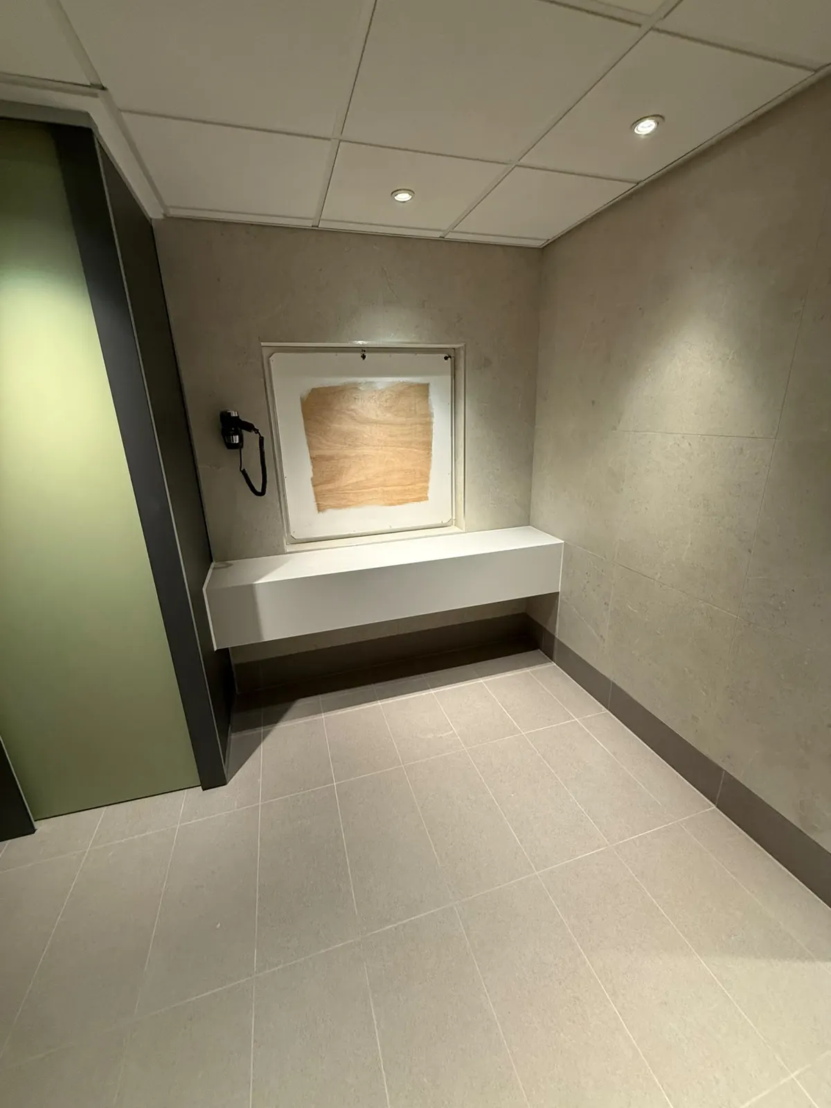 Wall-hung bench and mirror recess in the changing room, on EXT Core Grey 600 × 300 floor tiles with a tiled skirting
