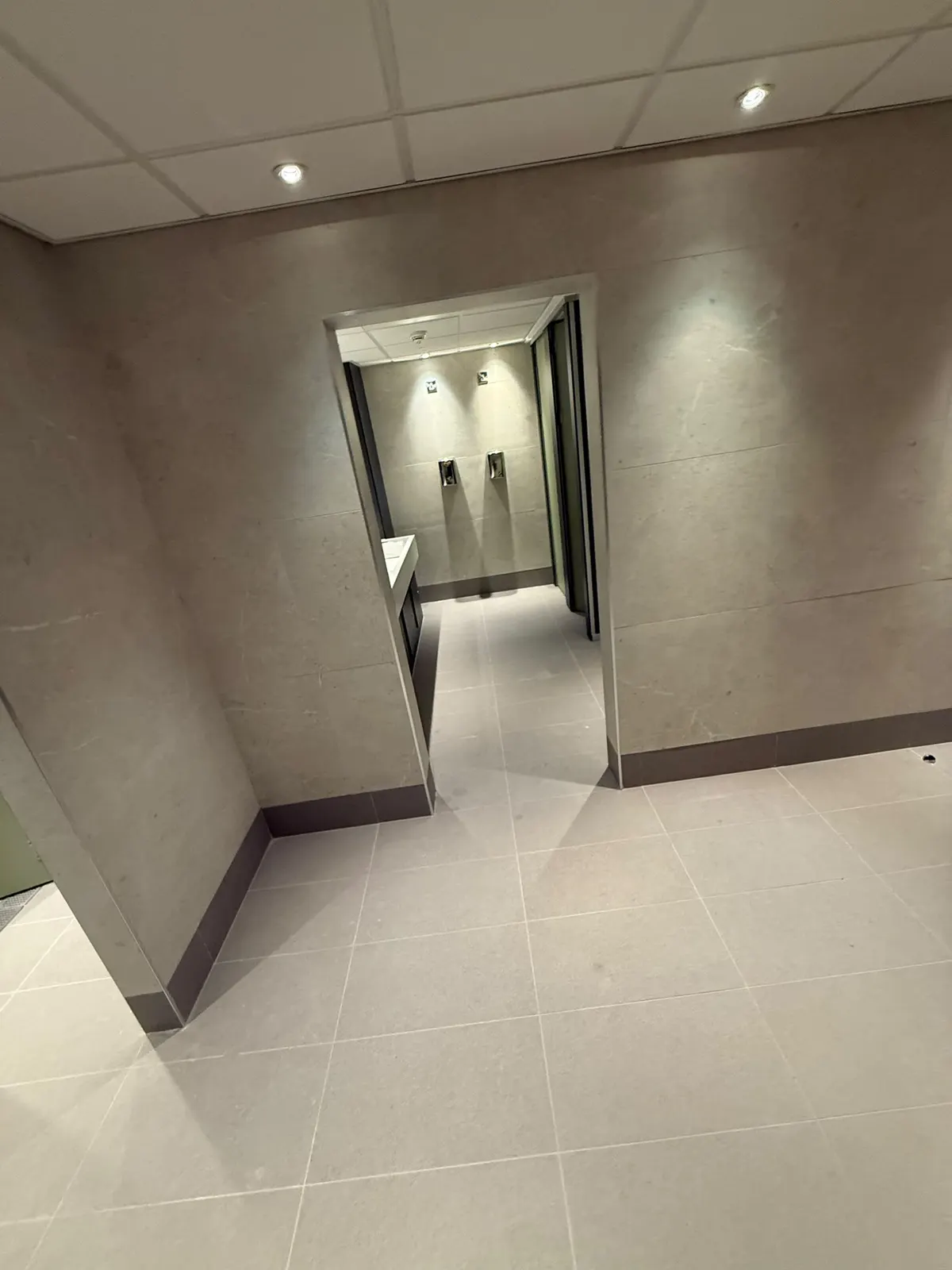 View from the changing room through to the washroom, with the floor tiling running through both spaces