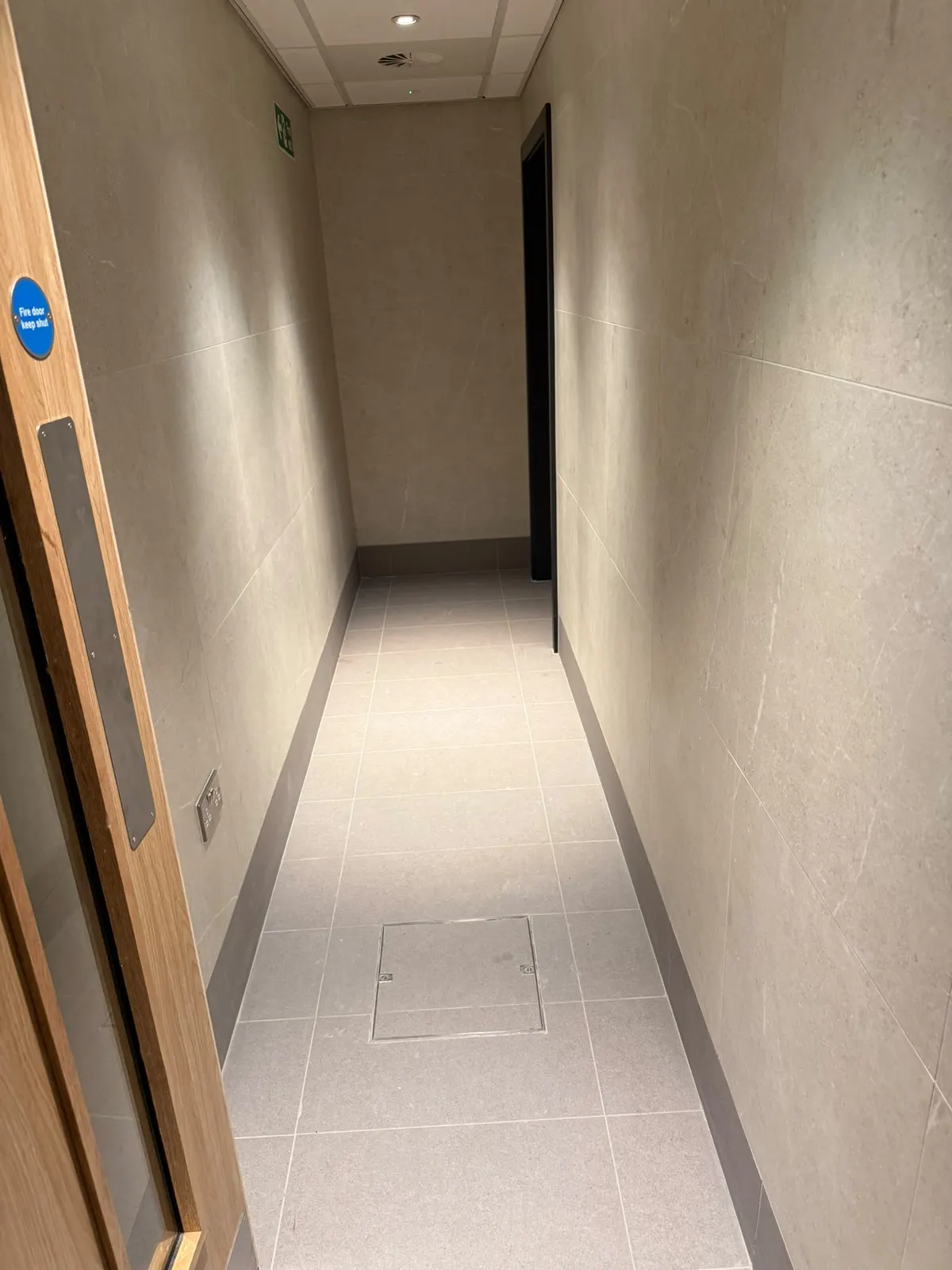 Corridor between the men’s and ladies’ changing rooms, tiled in Unika Light walls and EXT Core Grey floors