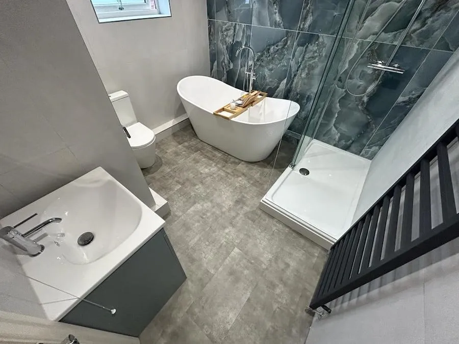 The full room from the door, with the vanity, bath and shower