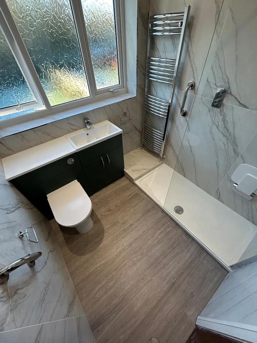 The finished room, with the shower, green vanity unit and wood-effect floor