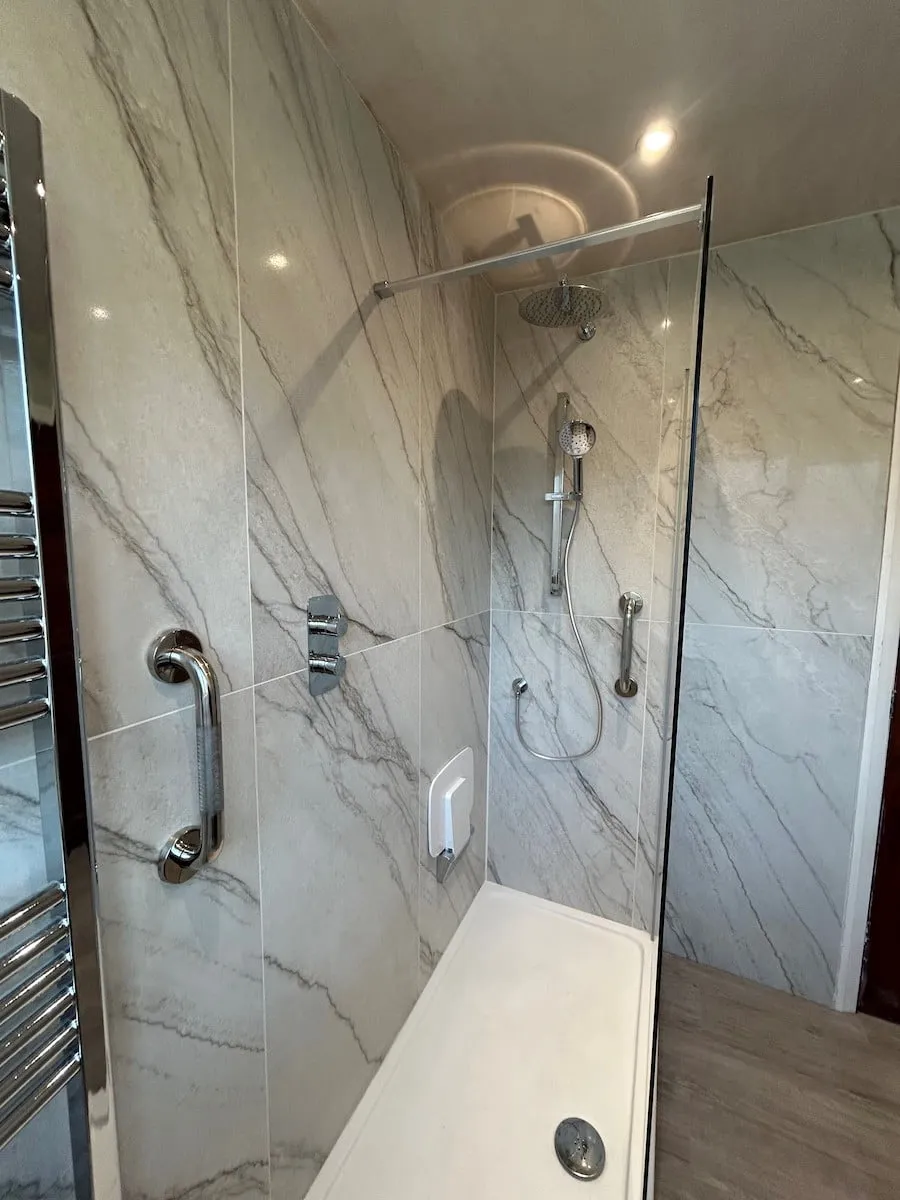 Large-format marble-effect tiles running full height in the shower
