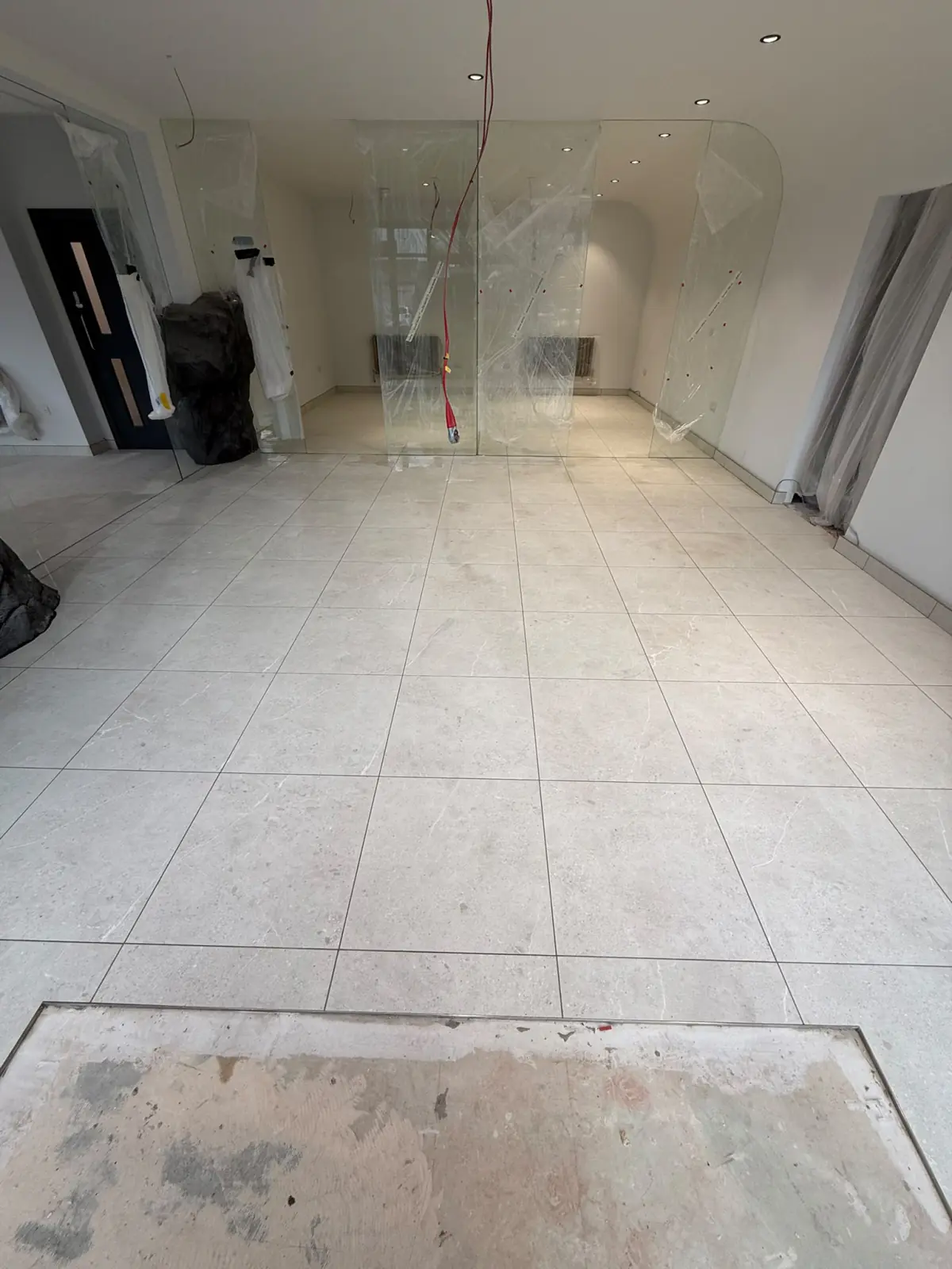 Light 600 × 600 tiles running the full length of the reception