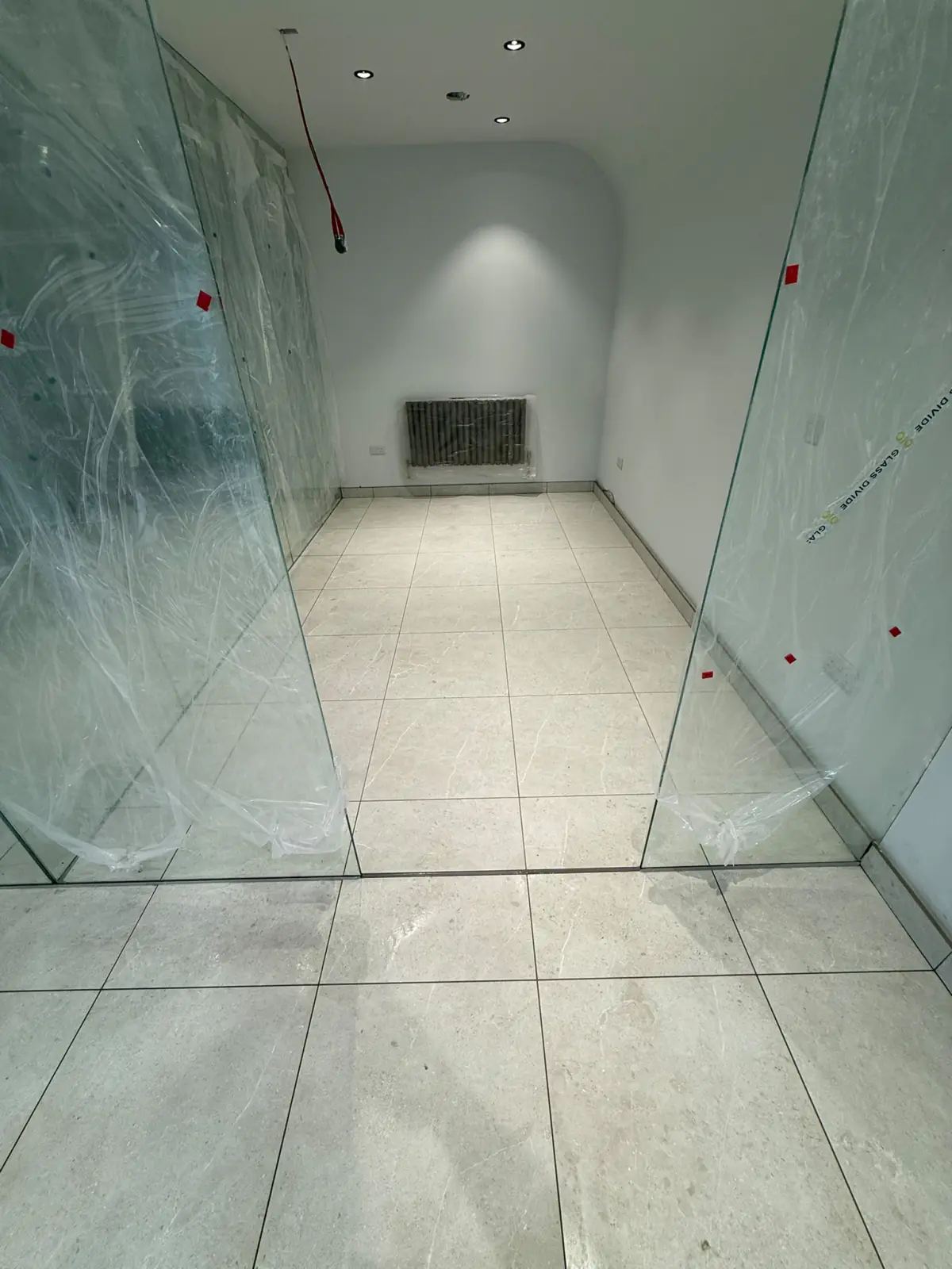 Glass-walled room with the tile joints set out to the partition line