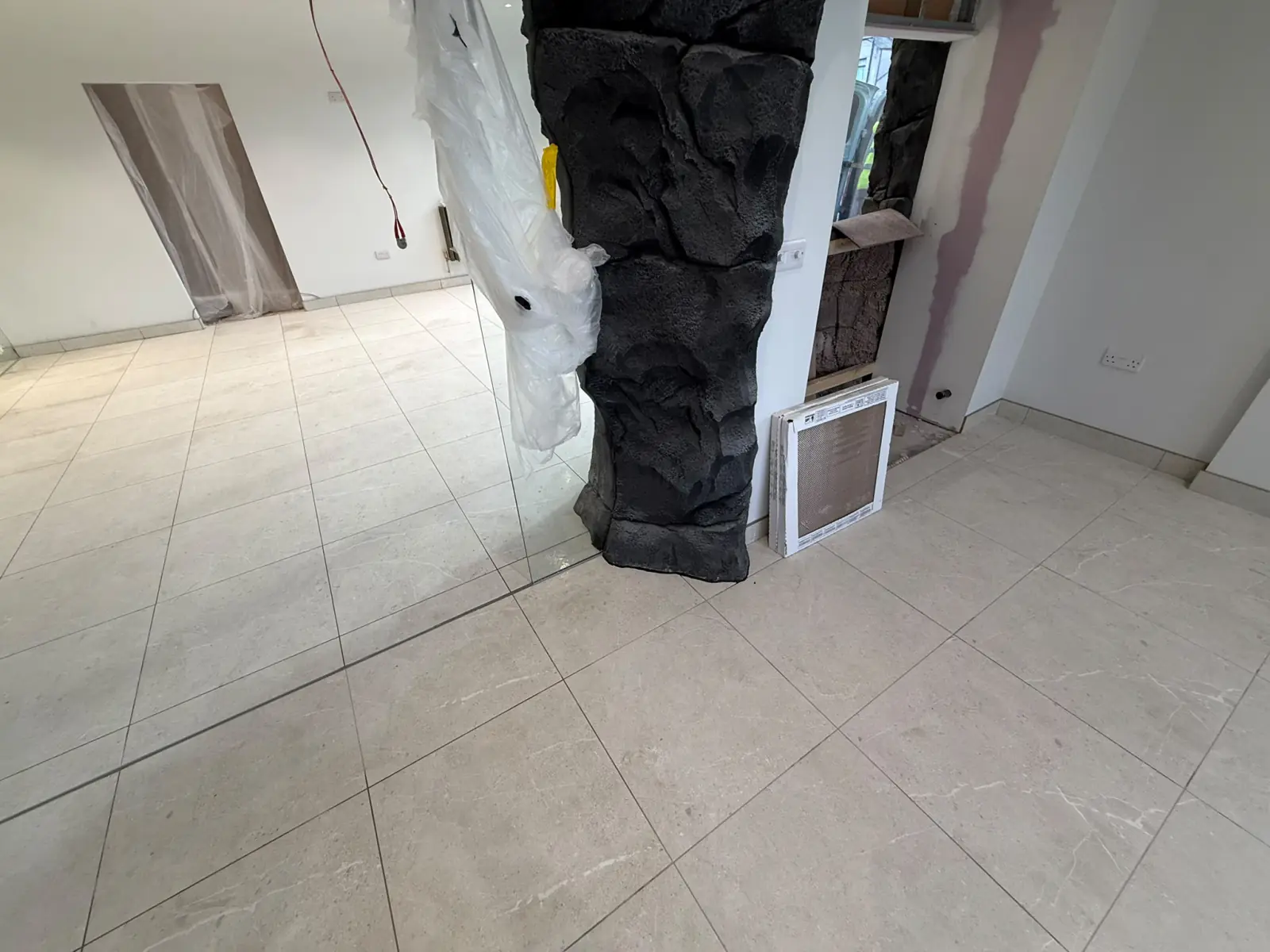 Tiles fitted around a rock-clad column and wall vent