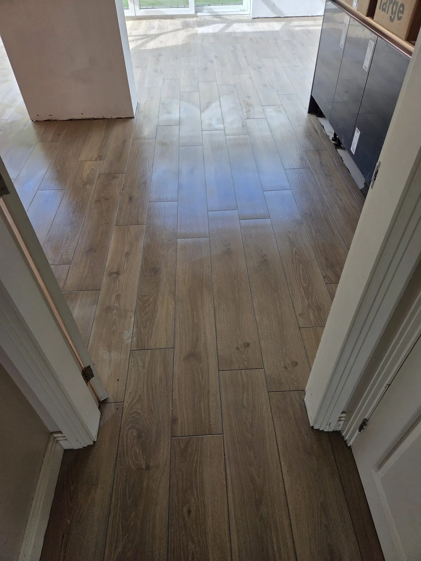 Wood-effect plank floor tiles through an open-plan ground floor