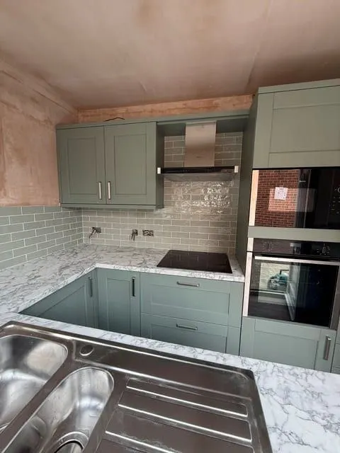Green metro tiling behind an induction hob