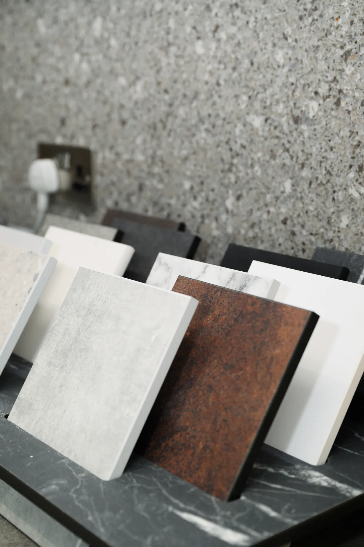 Worktop and tile samples against a terrazzo-effect wall