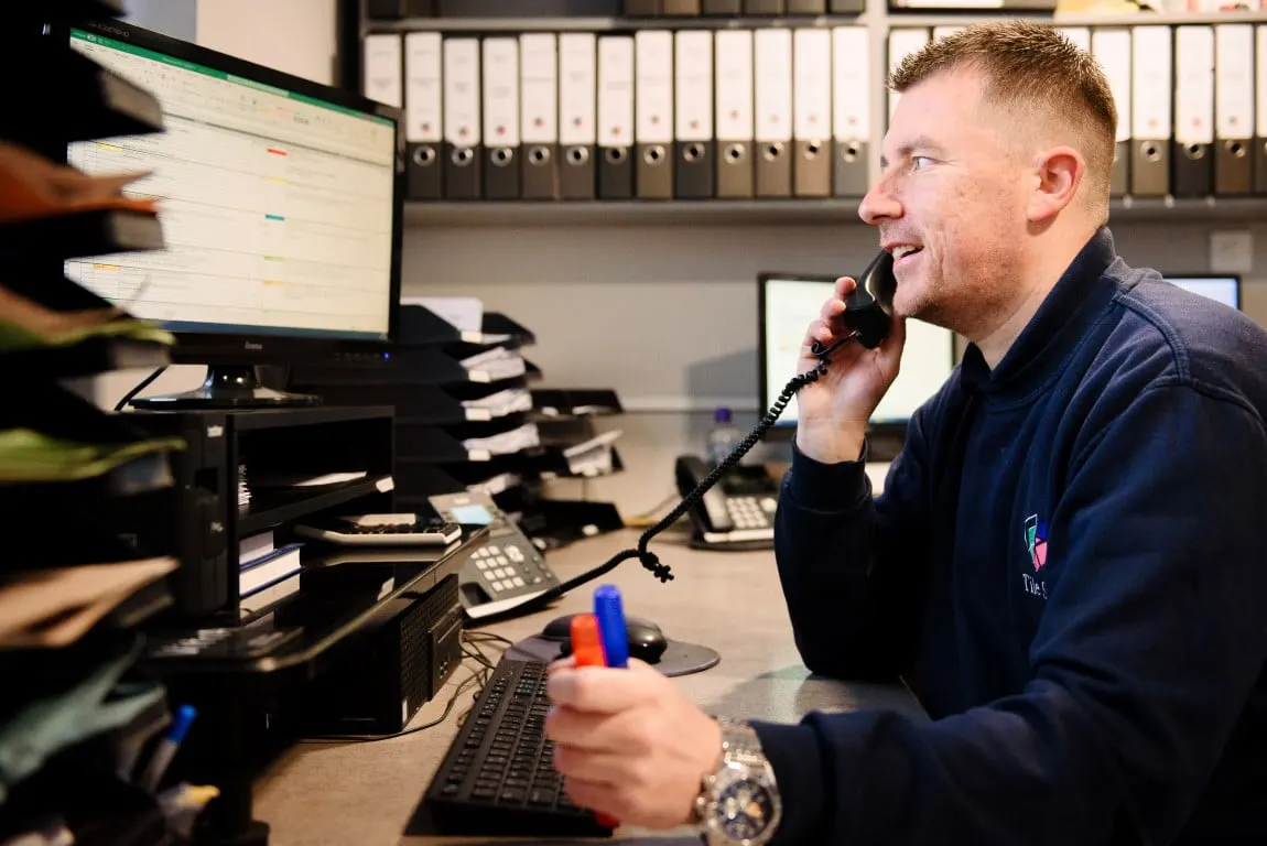 A Tile Style team member on the phone at a desk in the office